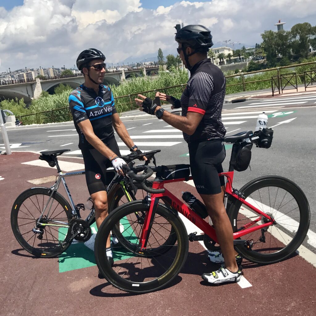 Two Men Standing by the Side of a Cycling Track