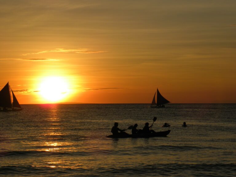A Sunset Scene by the Ocean Body With Rowing Boats