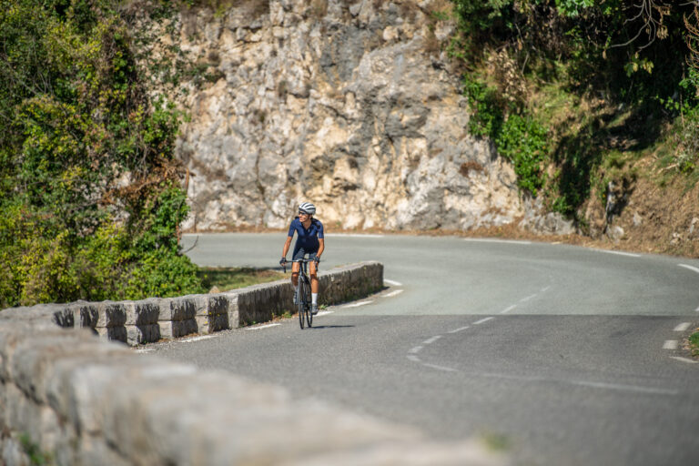 A Lone Cyclist Going Up a Hill by a Mountain