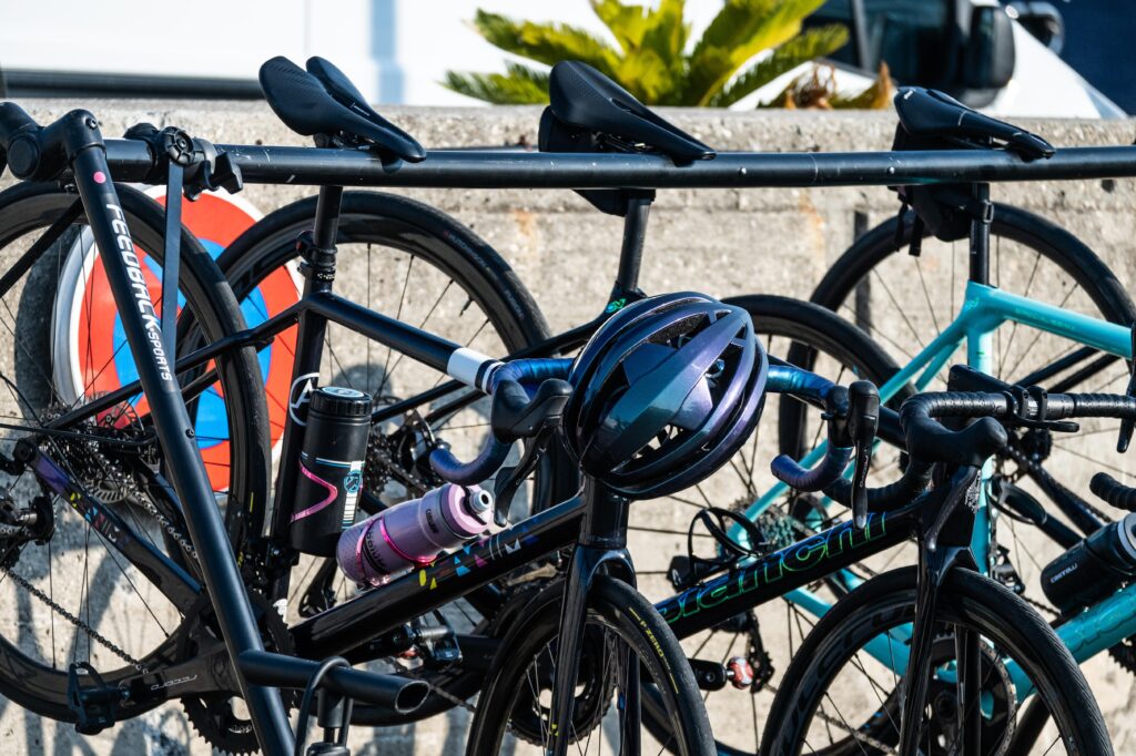 Bicycles parked with helmets and water bottles.