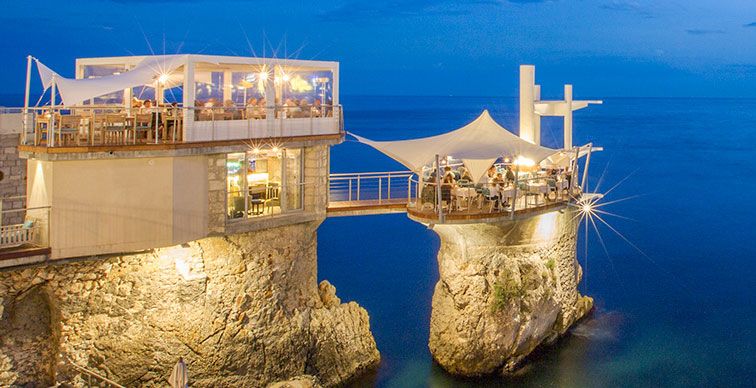 Cliffside restaurant over sea at dusk