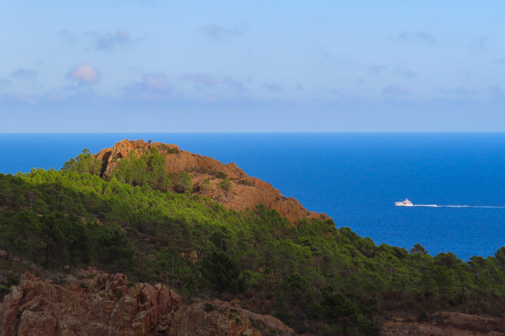 Rocky coastal cliffs with yacht on ocean